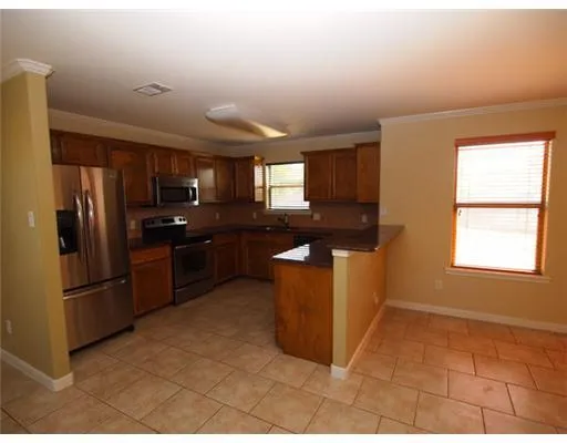 a kitchen with stainless steel appliances granite countertop a refrigerator a sink a stove a microwave and island