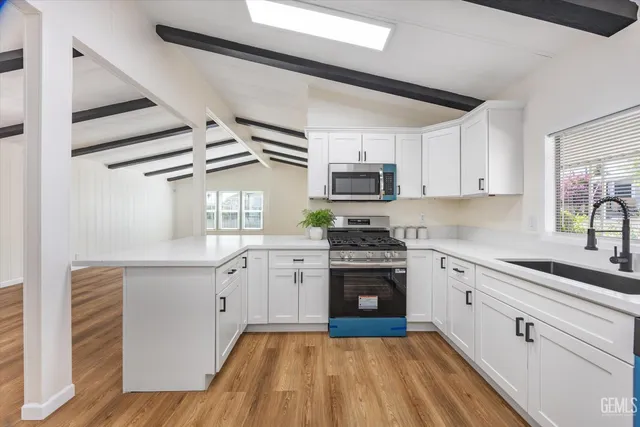 a kitchen with granite countertop a sink appliances cabinets and counter space
