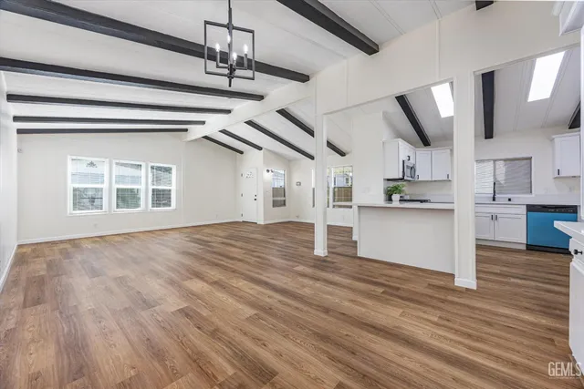 a view of empty room with wooden floor and window