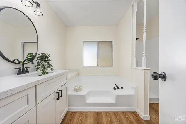 a bathroom with a bathtub sink and mirror