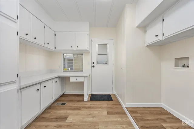 a room view with wooden floor and cabinets