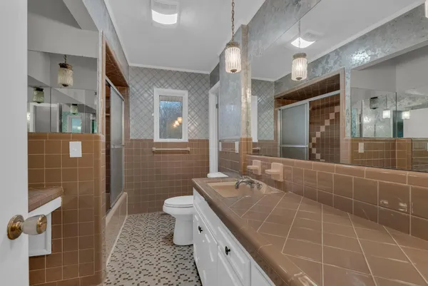 a bathroom with a double vanity sink a toilet and a mirror