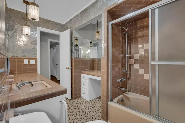 a bathroom with a sink a toilet and shower