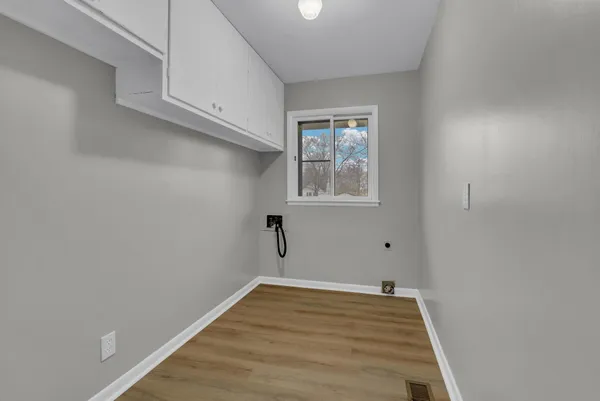 a view of a room with wooden floor and cabinets