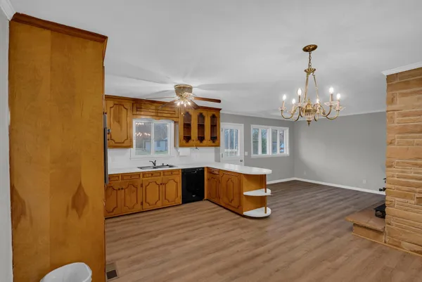 a kitchen with stainless steel appliances granite countertop a sink cabinets and wooden floor