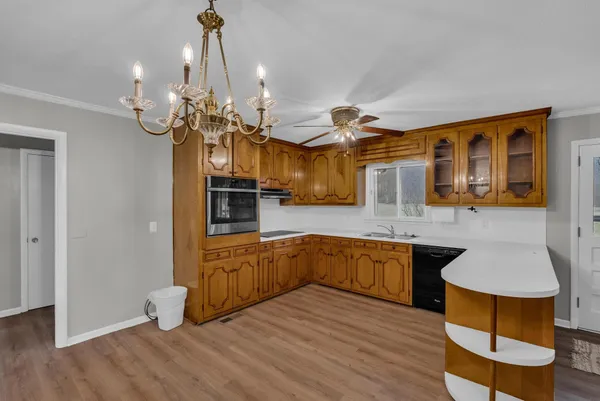 a kitchen with stainless steel appliances granite countertop a sink and wooden floor