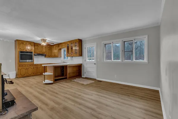 a living room with stainless steel appliances kitchen island furniture and wooden floor