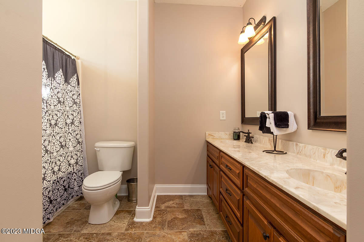 170 Terrell Road Elko, GA 31025 - Photo 18 of 35 a bathroom with a granite countertop toilet a sink and a mirror