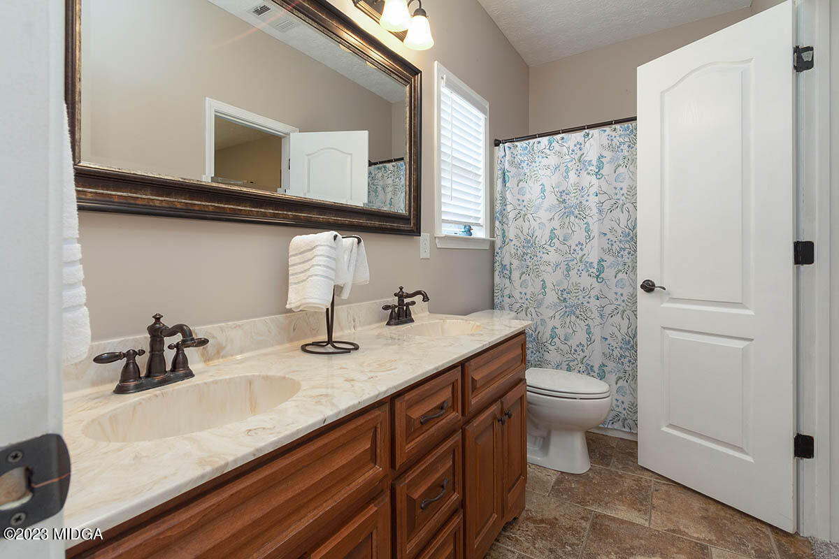 170 Terrell Road Elko, GA 31025 - Photo 21 of 35 a bathroom with a granite countertop sink toilet and mirror