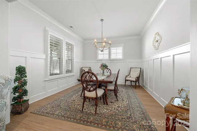 a bedroom with a bed a chandelier and a flat screen television
