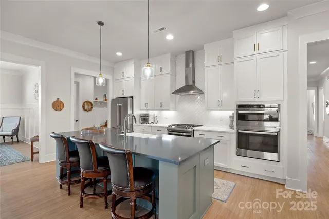 a large kitchen with kitchen island a stove a sink a refrigerator and a fireplace