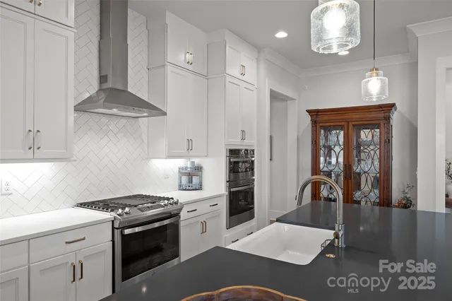 a large kitchen with sink a stove and chairs with wooden floor