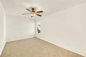 an empty room with a window and a ceiling fan