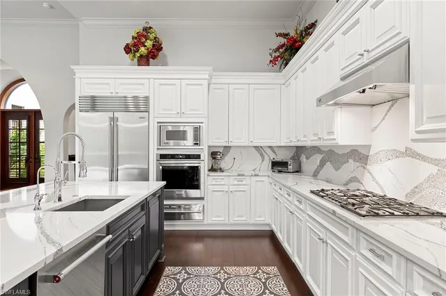 a kitchen with stainless steel appliances granite countertop a sink stove and cabinets