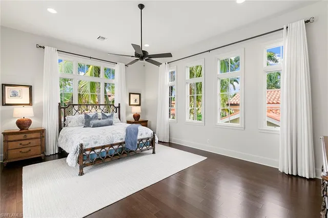 a spacious bedroom with a bed chandelier and a window
