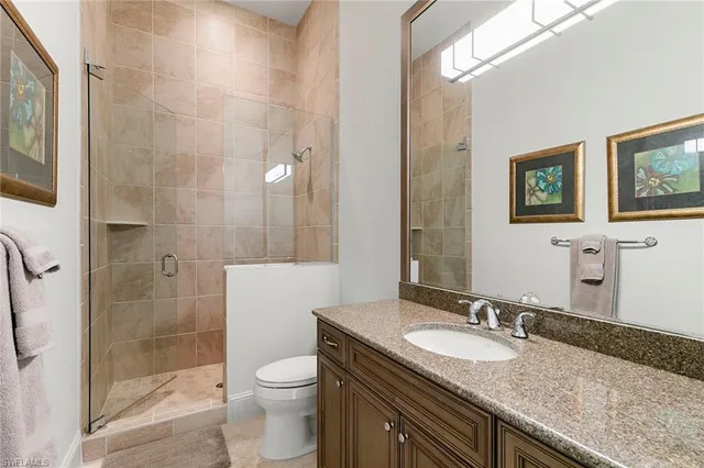 a bathroom with a granite countertop sink toilet and shower