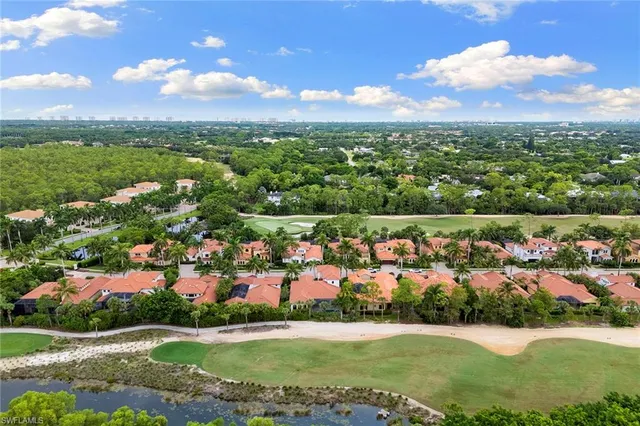 an aerial view of a city with lots of residential buildings ocean and mountain view in back