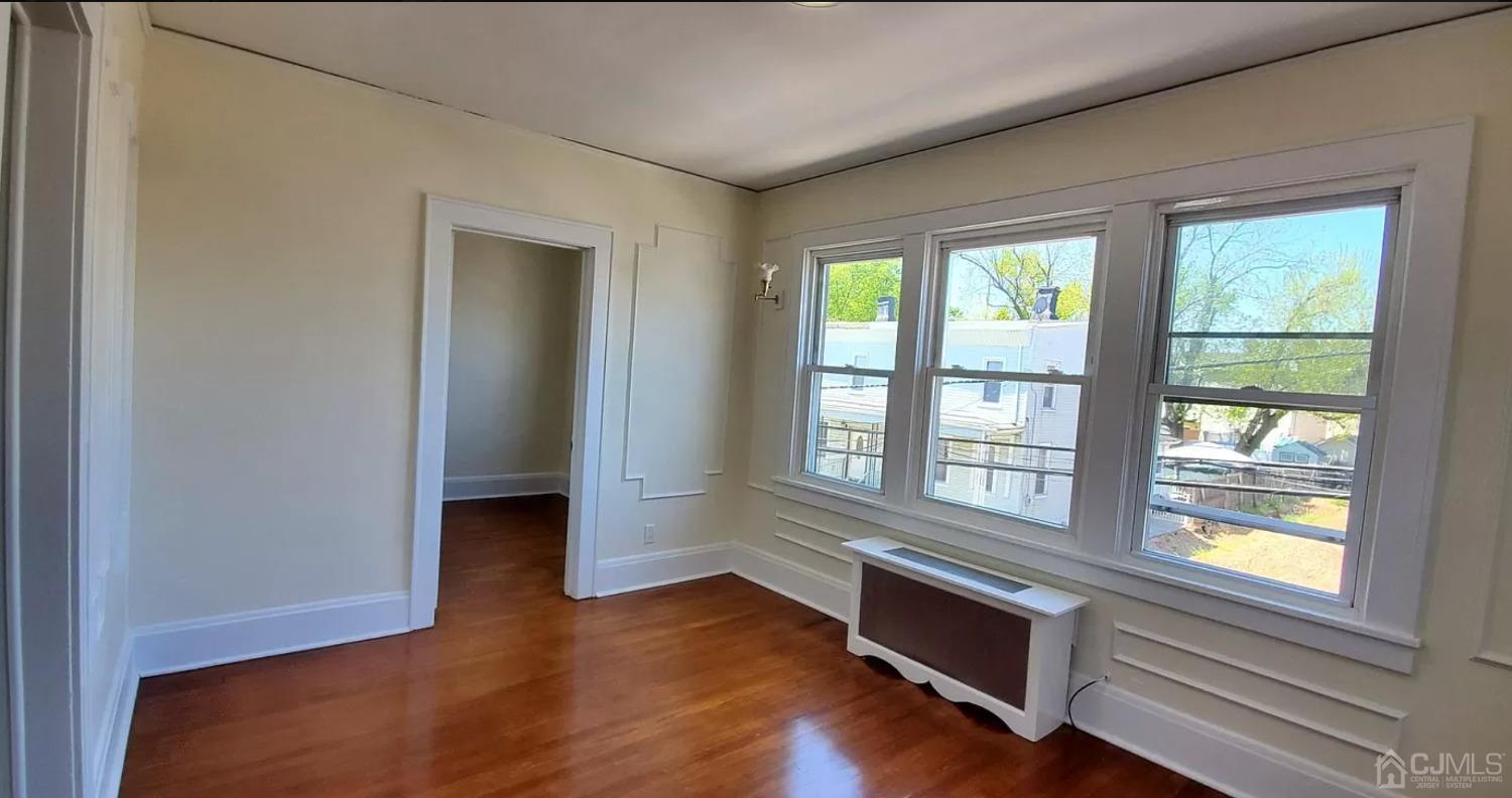 116 Race Street Elizabeth, NJ 07202 - Photo 2 of 7 a view of an empty room with wooden floor and a window