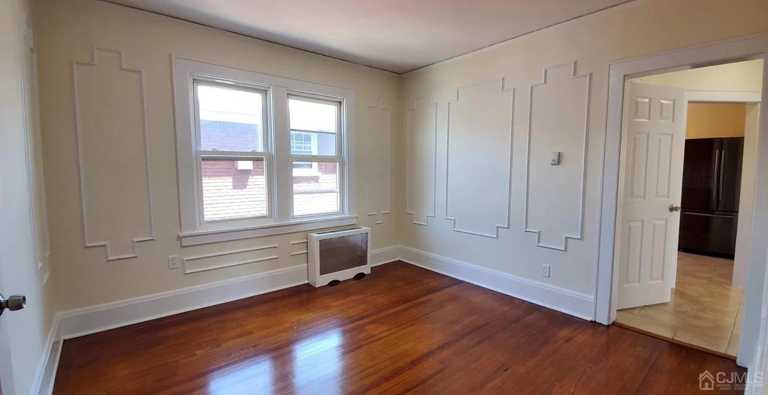 116 Race Street Elizabeth, NJ 07202 - Photo 3 of 7 an empty room with wooden floor and windows