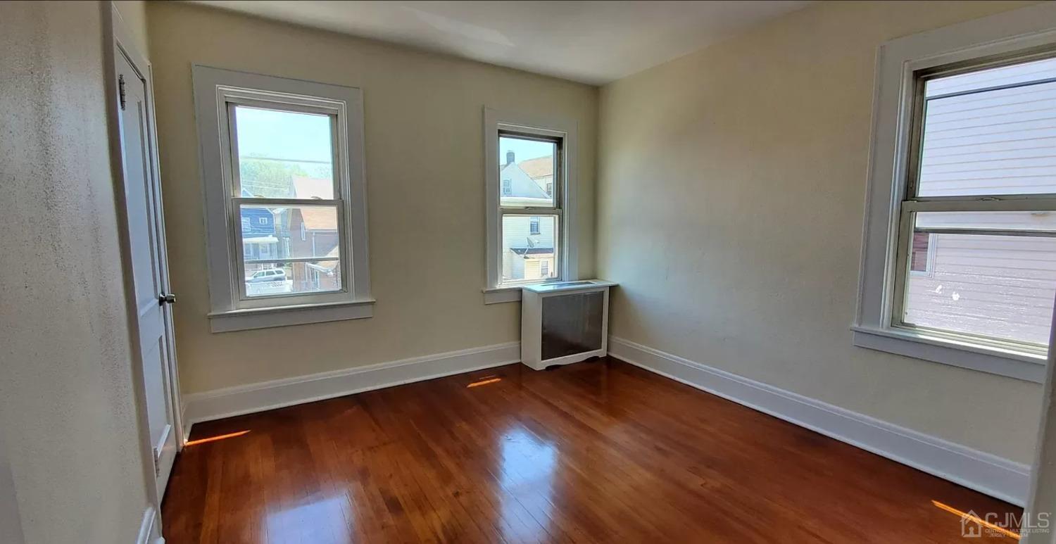 116 Race Street Elizabeth, NJ 07202 - Photo 6 of 7 a view of empty room with wooden floor and fan