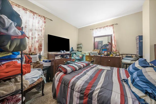 a bed room with a bed television and a large window