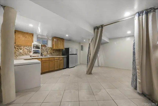 a kitchen with a sink a refrigerator and cabinets