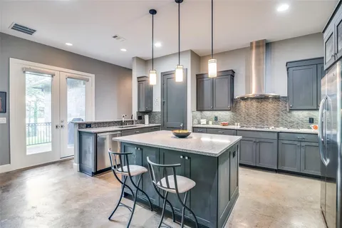 a kitchen that has a lot of cabinets in it wooden floor and appliances