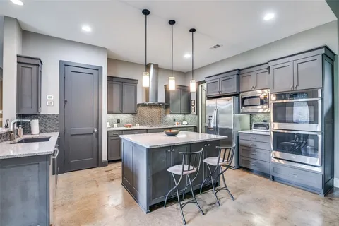a kitchen with kitchen island a counter top space appliances and a chandelier