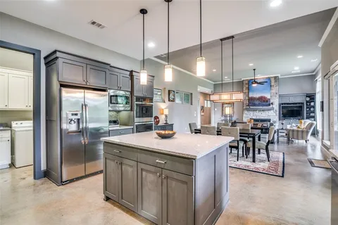 a kitchen with granite countertop stove a sink a dining table and chairs