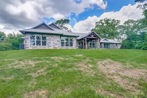 a view of a house with a big yard and large trees