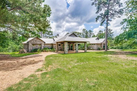 a front view of a house with yard and green space