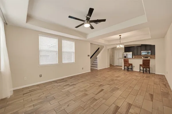 a view of an empty room with a window and a ceiling fan