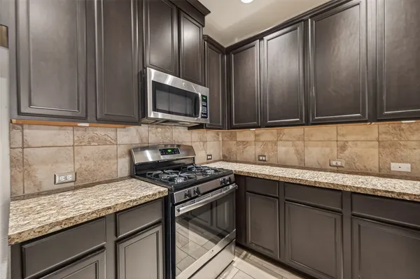 a kitchen with granite countertop cabinets stainless steel appliances and wooden cabinets