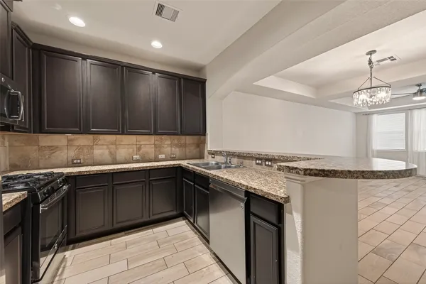 a kitchen with stainless steel appliances granite countertop a sink stove and cabinets