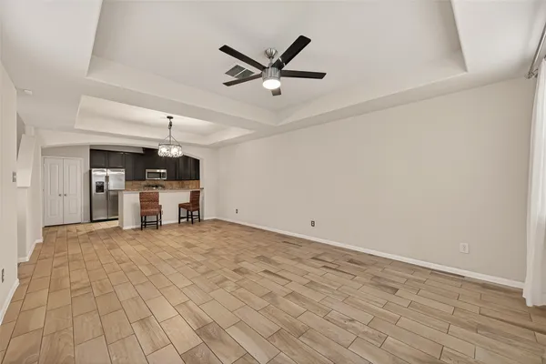 a view of a livingroom with a piano and wooden floor