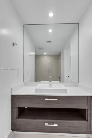 a bathroom with a sink a light fixture and a mirror