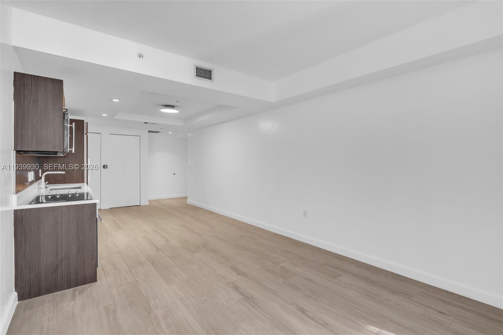55 Southwest 9th Street, Unit 1109 Miami, FL 33130 - Photo 10 of 35 a view of a kitchen with a sink and dishwasher a refrigerator with wooden floor
