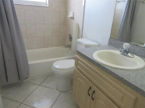 a bathroom with a granite countertop toilet a sink and bathtub