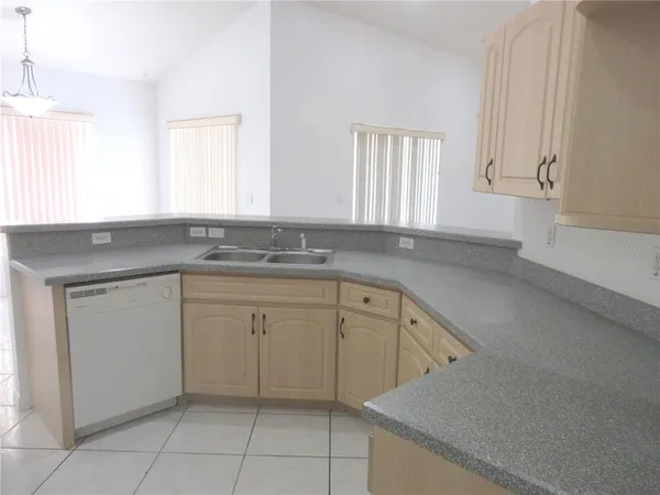 a kitchen with white cabinets granite counter tops and a window