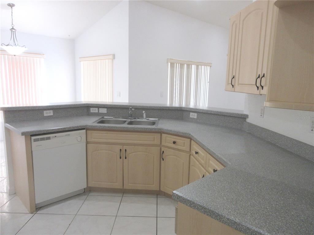 4760 Southwest 136th Place Ocala, FL 34473 - Photo 5 of 19 a kitchen with white cabinets granite counter tops and a window