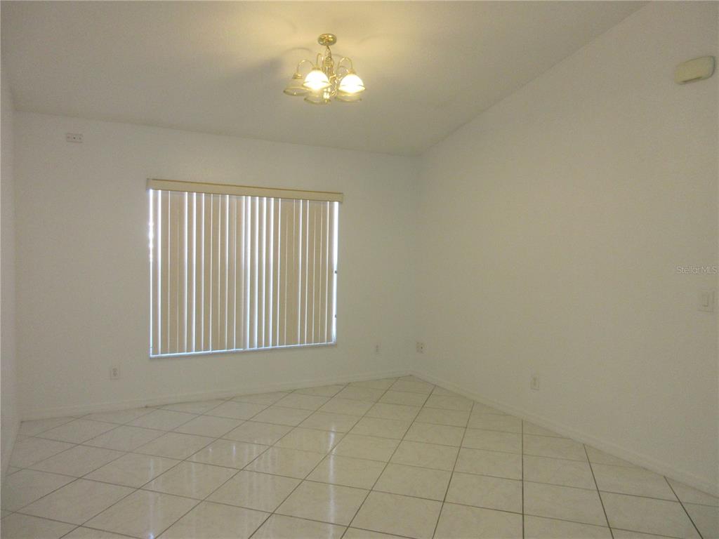 4760 Southwest 136th Place Ocala, FL 34473 - Photo 9 of 19 an empty room with windows and chandelier fan