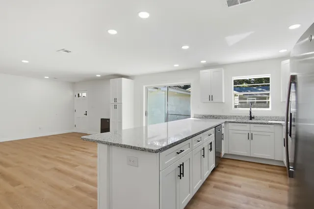 a kitchen with cabinets appliances a sink and a window