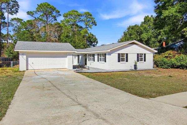 a front view of a house with a yard and trees