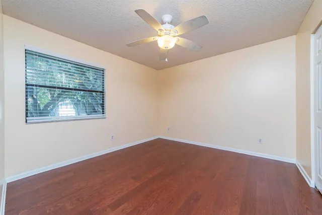 an empty room with a window and a ceiling fan