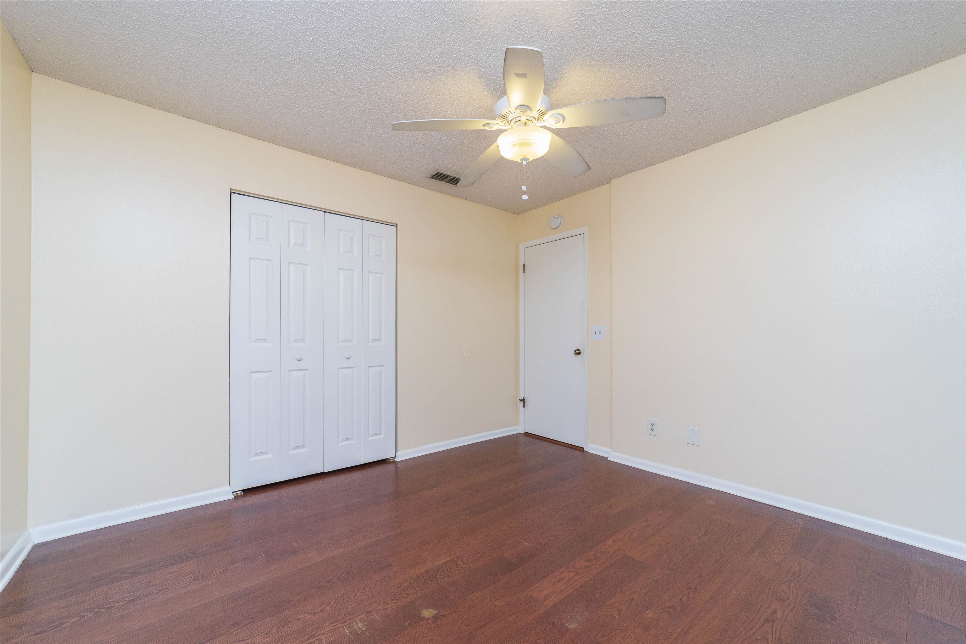 2 Catalonia Court St. Augustine, FL 32086 - Photo 15 of 28 an empty room with a chandelier fan and wooden floor