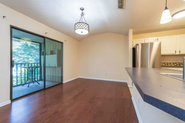 a view of a room with wooden floor and an empty room