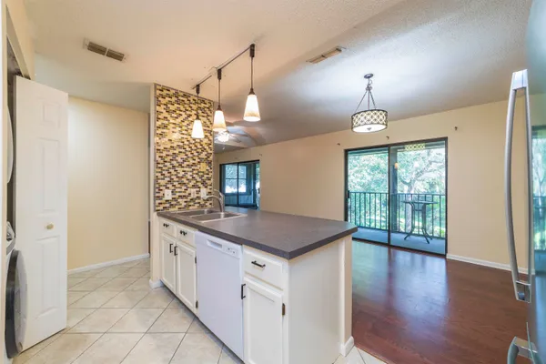 a kitchen with stainless steel appliances granite countertop a sink a stove and a window