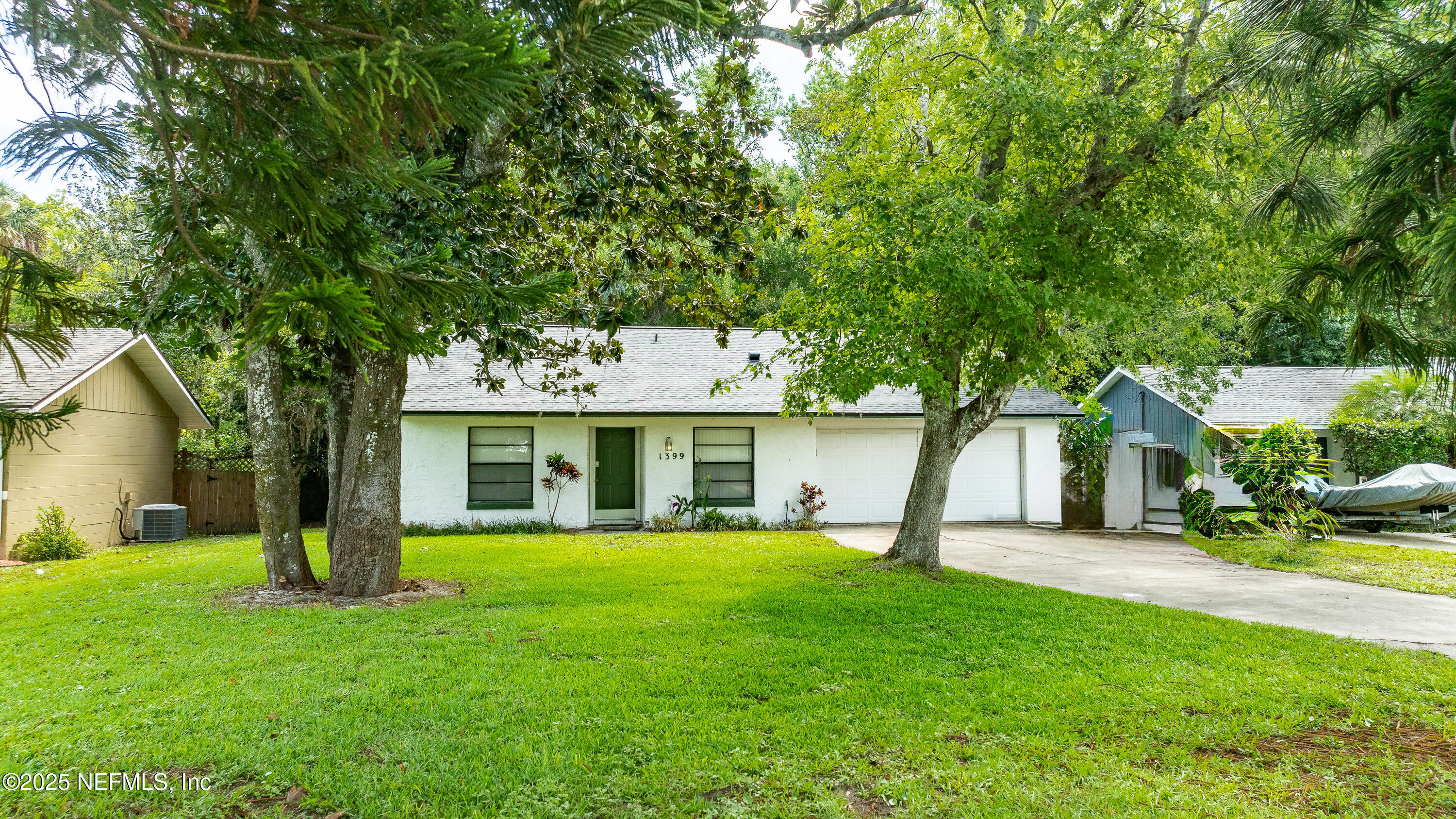 a view of a house with a yard and a tree