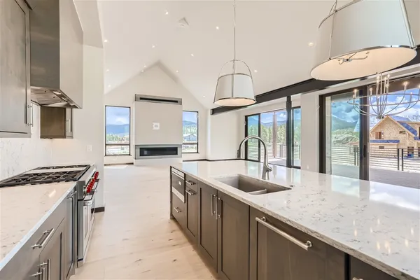 a spacious kitchen with stainless steel appliances granite countertop a stove and a wooden floors