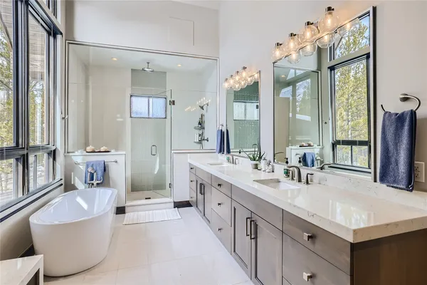 a spacious bathroom with a double vanity sink a mirror and a bathtub